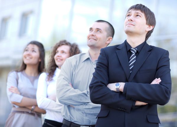 تیم تجاری در یک ردیف در دفتر ایستاده و به سمت بالا نگاه می کند - تیم تجاری موفق