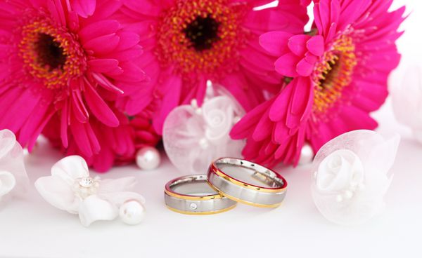 طبیعت بی جان عروسی با حلقه های طلایی زیبا و دسته گل در پس زمینه