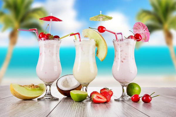نوشیدنی پینا کولادا با ساحل تاری در پس‌زمینه