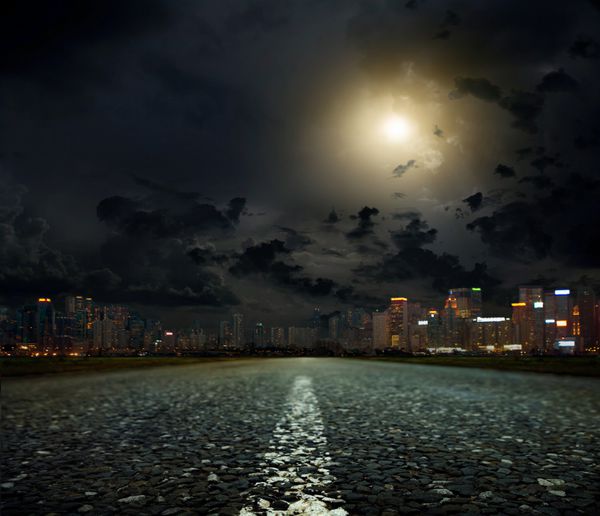 جاده آسفالته منتهی به شهر در شب