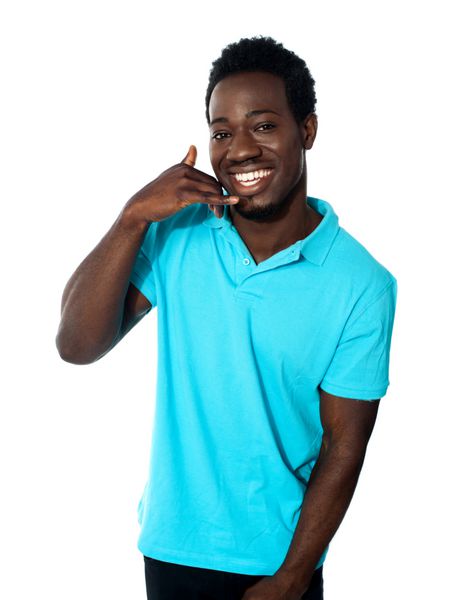 مرد جوان خندان در حال نشان دادن ژست تماس جدا شده در پس زمینه سفید
