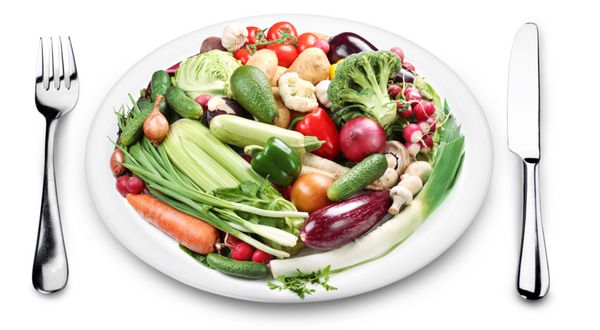 مقدار زیادی سبزیجات در یک بشقاب تصویر در زمینه سفید