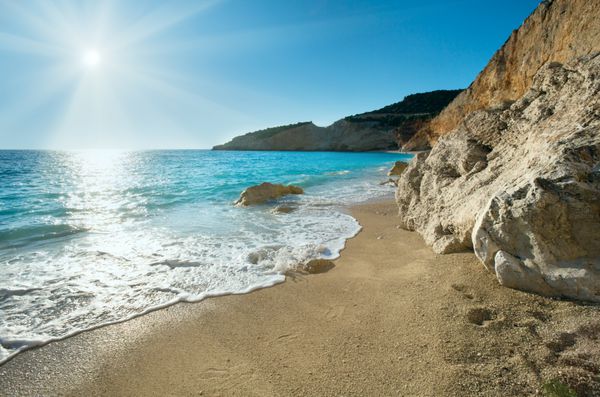 ساحل زیبای تابستانی پورتو کاتسیکی در دریای ایونی لفکادا یونان با خورشید در آسمان