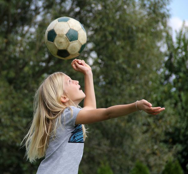 دختر بلوند 11 ساله با توپ بازی می کند و به سر توپ می رسد
