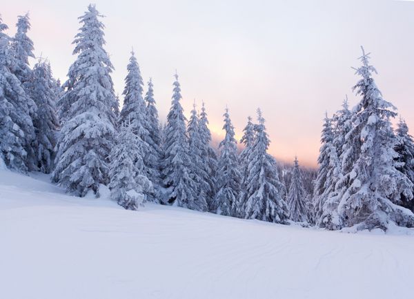 منظره زمستانی زیبا در کوهستان طلوع خورشید