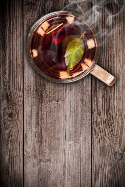 نمای بالای چای میوه ای روی میز تخته ای چوبی