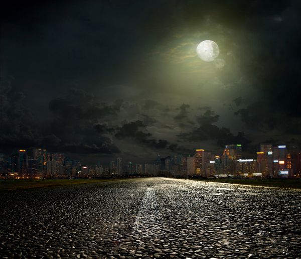جاده آسفالته منتهی به شهر در شب
