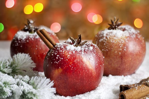 سیب های غذای کریسمس در نزدیکی برف و پس زمینه تار