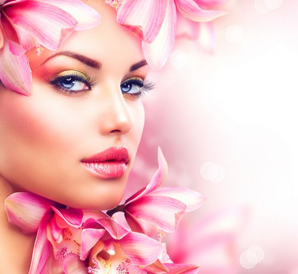 دختر زیبایی با گل های ارکیده صورت زن مدل زیبا پوست کامل میکاپ حرفه ای آرایش هنر مد