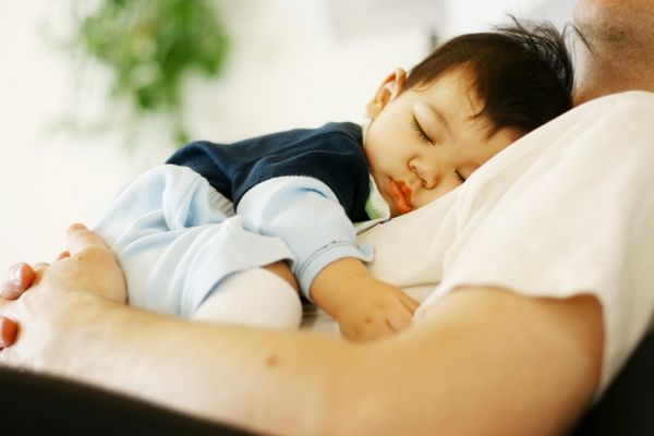 پسر بچه دو نژادی ناز که روی سینه پدر خوابیده است