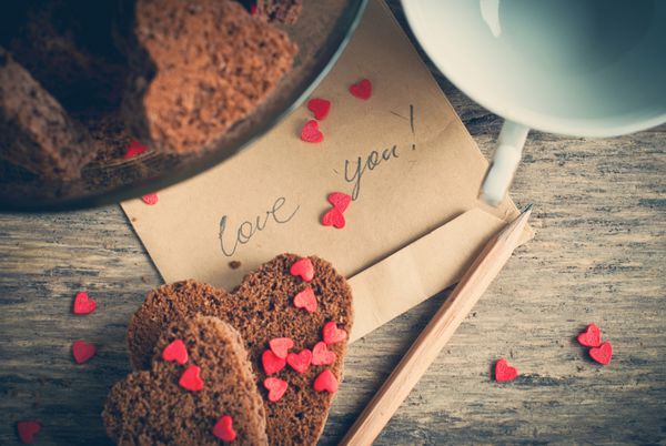 کارت با پیام دوست دارم در نامه و شکلات کوکی شکل قلب در روز ولنتاین
