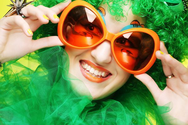 زن جوان شاد با موهای سبز و عینک کارناوال