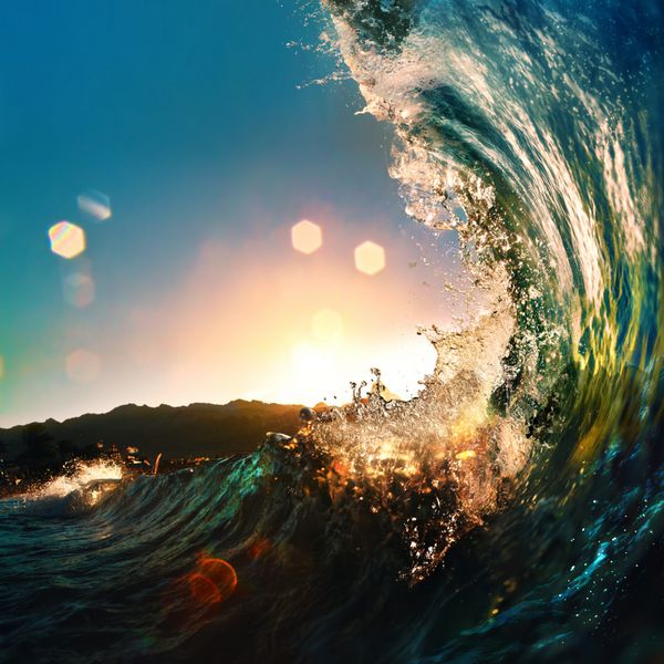 موج زیبای رنگارنگ اقیانوسی که در زمان غروب خورشید فرو می‌ریزد