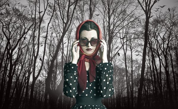 عکس هنری زیبا از یک زن زیبا با عینک آفتابی در جلوی درختان