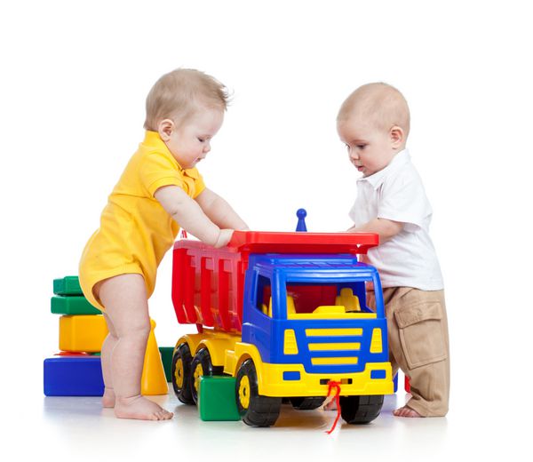 دو کودک کوچک در حال بازی با اسباب بازی های رنگی