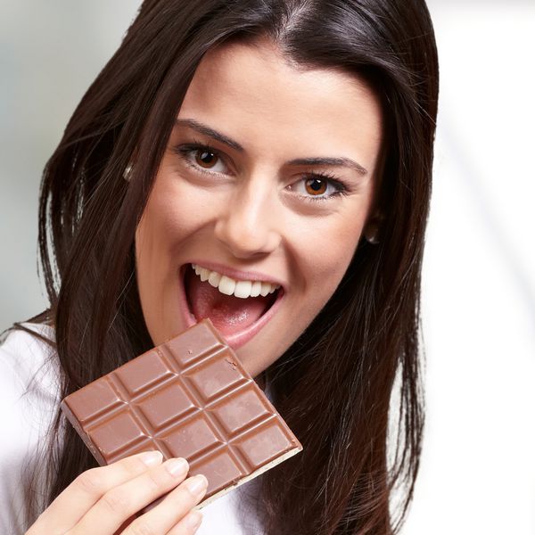 پرتره یک زن در حال خوردن شکلات پس زمینه