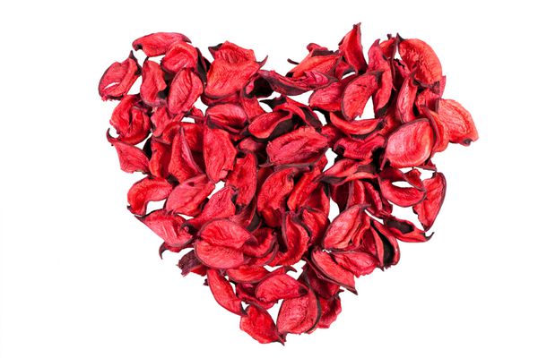 گلبرگ های رز قرمز خشک به شکل قلب جدا شده در زمینه سفید