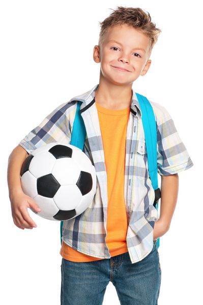 پسر مدرسه ای شاد با کوله پشتی و توپ فوتبال جدا شده در پس زمینه سفید