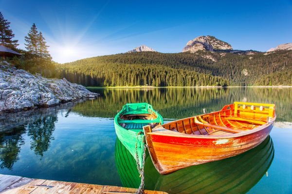 انعکاس در آب دریاچه ها و قایق های کوهستانی دریاچه سیاه در پارک ملی دورمیتور در مونته نگرو اروپا دنیای زیبایی