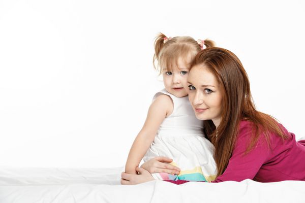 زن شاد و دختر جوان کودک در رختخواب خندان مفهوم روز مادر