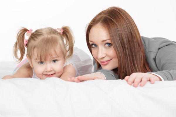 زن شاد و دختر جوان کودک در رختخواب خندان مفهوم روز مادر