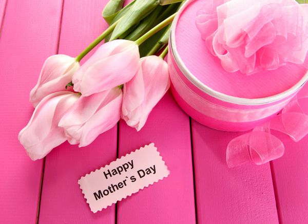 دسته گل زیبای لاله و هدیه روز مادر در زمینه چوبی صورتی