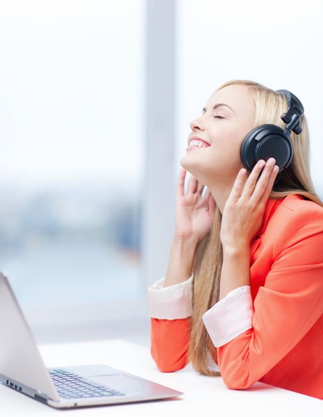 زن شاد با هدفون در حال گوش دادن به موسیقی