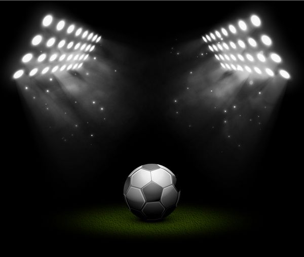 توپ فوتبال در نور نورافکن تصویر شامل شفافیت و جلوه های ترکیبی است