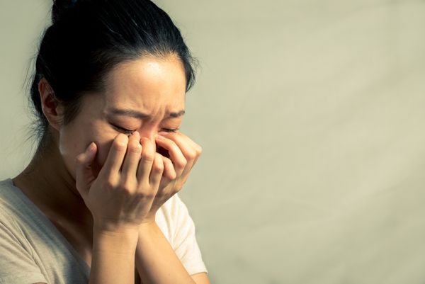 زن جوان در حال گریه و پاک کردن اشک با لحن مد