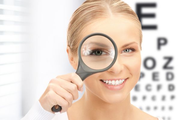 مفهوم پزشکی و بینایی - زن با ذره بین و نمودار چشم