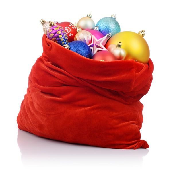 کیف قرمز بابا نوئل با اسباب بازی های کریسمس در پس زمینه سفید فایل حاوی مسیری برای جداسازی است
