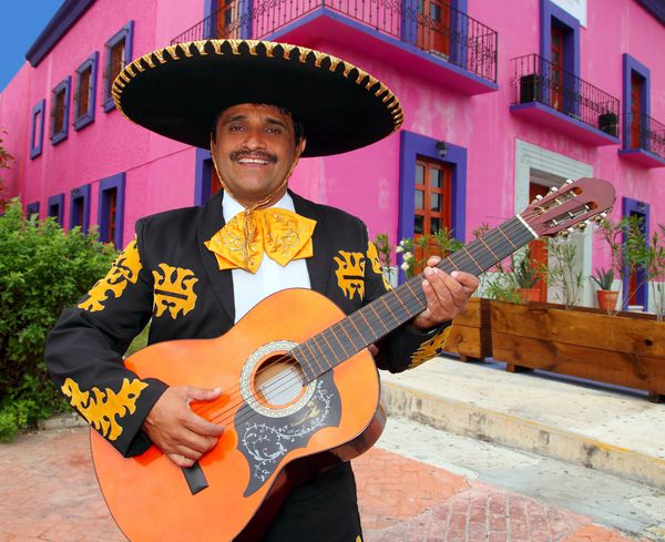خواننده چاررو ماریاچی در حال نواختن گیتار در مکزیک دارای پس زمینه است