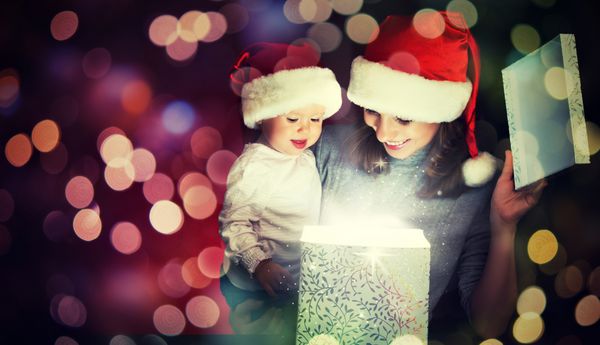 جعبه هدیه جادویی کریسمس و یک زن خانواده شاد مادر و کودک کودک