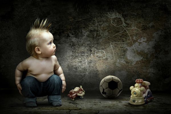 پسر بچه دور اسباب بازی هایش به تصویر روی دیوار گرانج نگاه می کند
