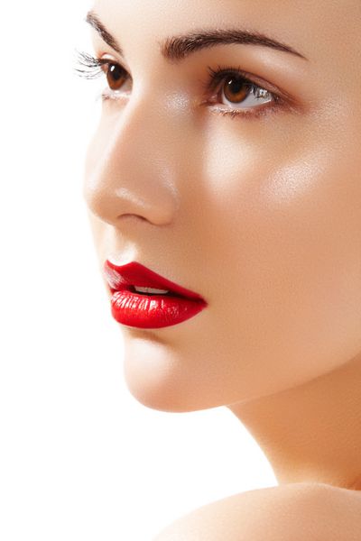 پرتره نمای نزدیک از چهره پاک زن زیبا با آرایش لب های قرمز روشن مدل زیبا با پوست براق تمیز
