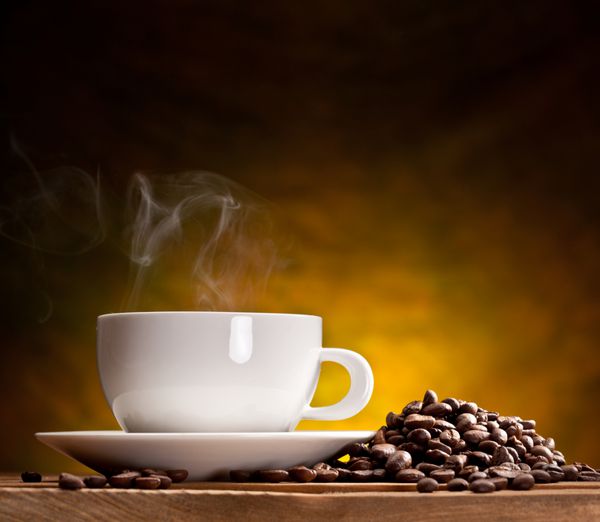 فنجان قهوه با دانه های قهوه در زمینه قهوه ای زیبا