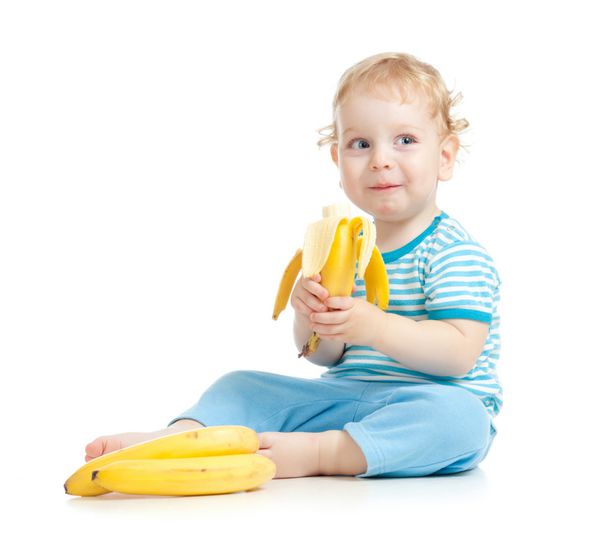 کودک شاد در حال خوردن میوه های غذایی سالم جدا شده روی سفید