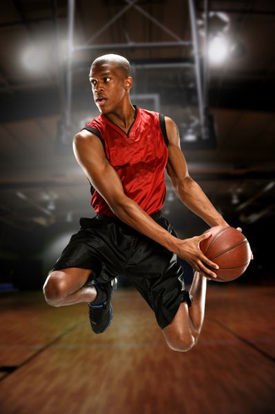 بازیکن جوان بسکتبال در حال پریدن در داخل زمین