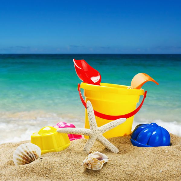اسباب بازی های رنگارنگ برای جعبه های شنی کودکان در برابر دریا و ساحل