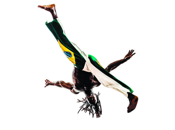 یک رقصنده مرد سیاهپوست برزیلی برزیلی در حال رقص کاپوئرا در پس زمینه سفید