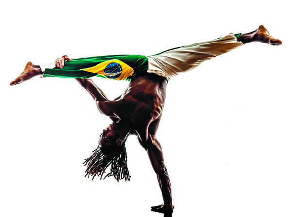 یک رقصنده مرد سیاهپوست برزیلی در حال رقص کاپوئرا در پس زمینه سفید