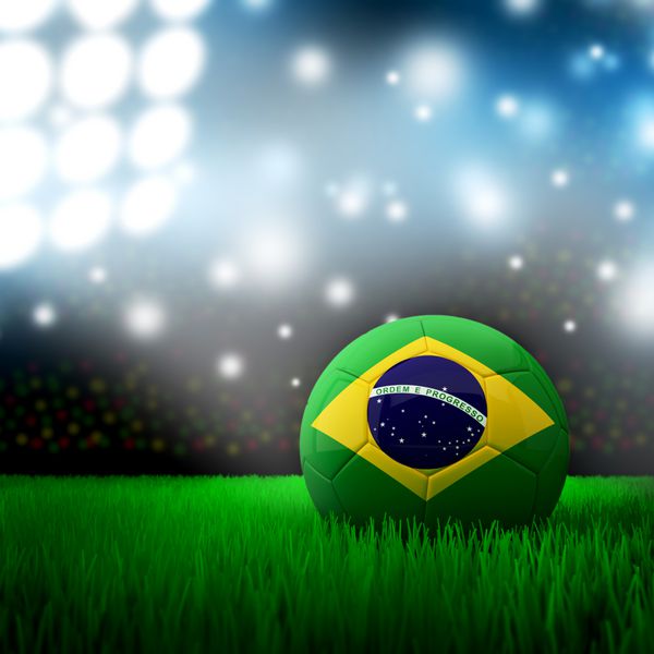 توپ فوتبال با پرچم برزیل روی چمن زیر نور ورزشگاه