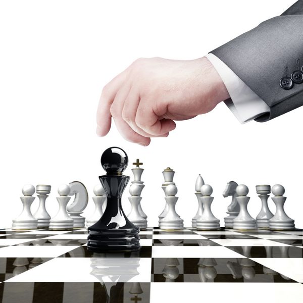 مفهوم استراتژی دستی که شکل شطرنج سیاه را در دست گرفته روی صفحه شطرنج جدا شده روی پس‌زمینه سفید وضوح بالا