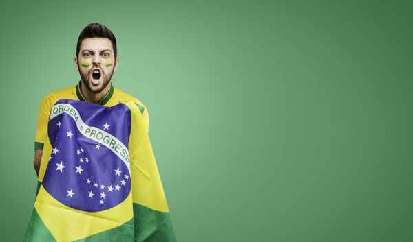 مرد برزیلی در پس زمینه سبز جشن می گیرد