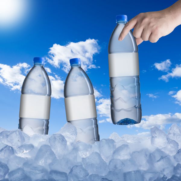 جمع آوری دستی بطری آب سرد از مکعب یخ در روز گرم تابستان