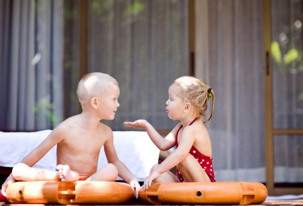 دو بچه در استخر به یکدیگر نگاه می کنند و با هم بحث می کنند