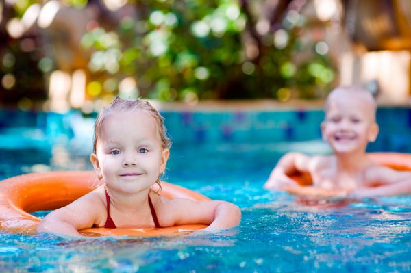 دو بچه با شناور نجات در استخر