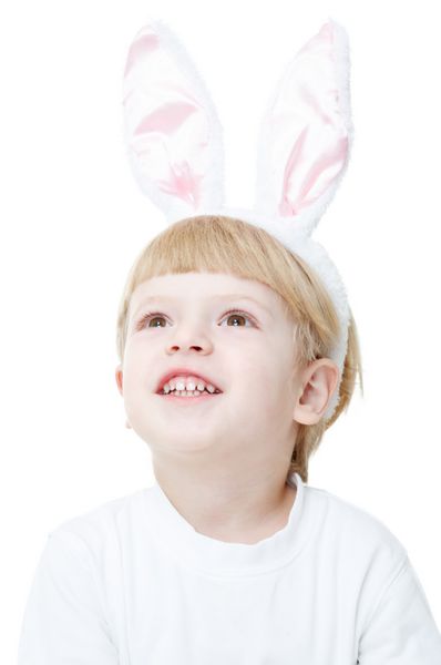 دختر کوچولوی شادی که گوش های اسم حیوان دست اموز به تن دارد جدا شده روی سفید به بالا نگاه می کند