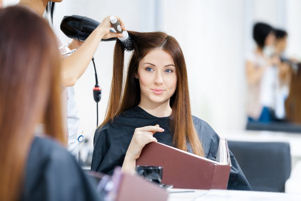 انعکاس آرایشگر در حال کوتاه کردن مو برای زنان در آرایشگاه مفهوم مد و زیبایی