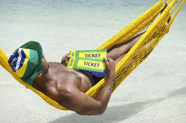 مرد برزیلی در حال استراحت در بانوج ساحلی با دو بلیط برزیل